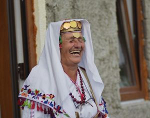 A local Lukomir woman laughing in traditional bosnian village highlands costume clothing