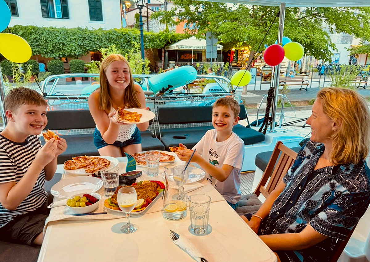 Family gathered at a birthday table with balloons on board