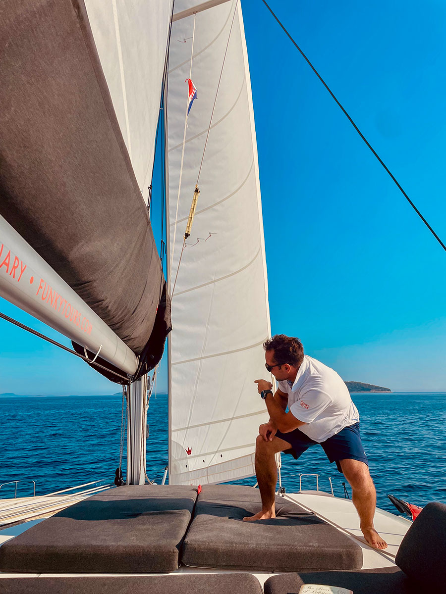 Skipper handling a sail on the catamaran