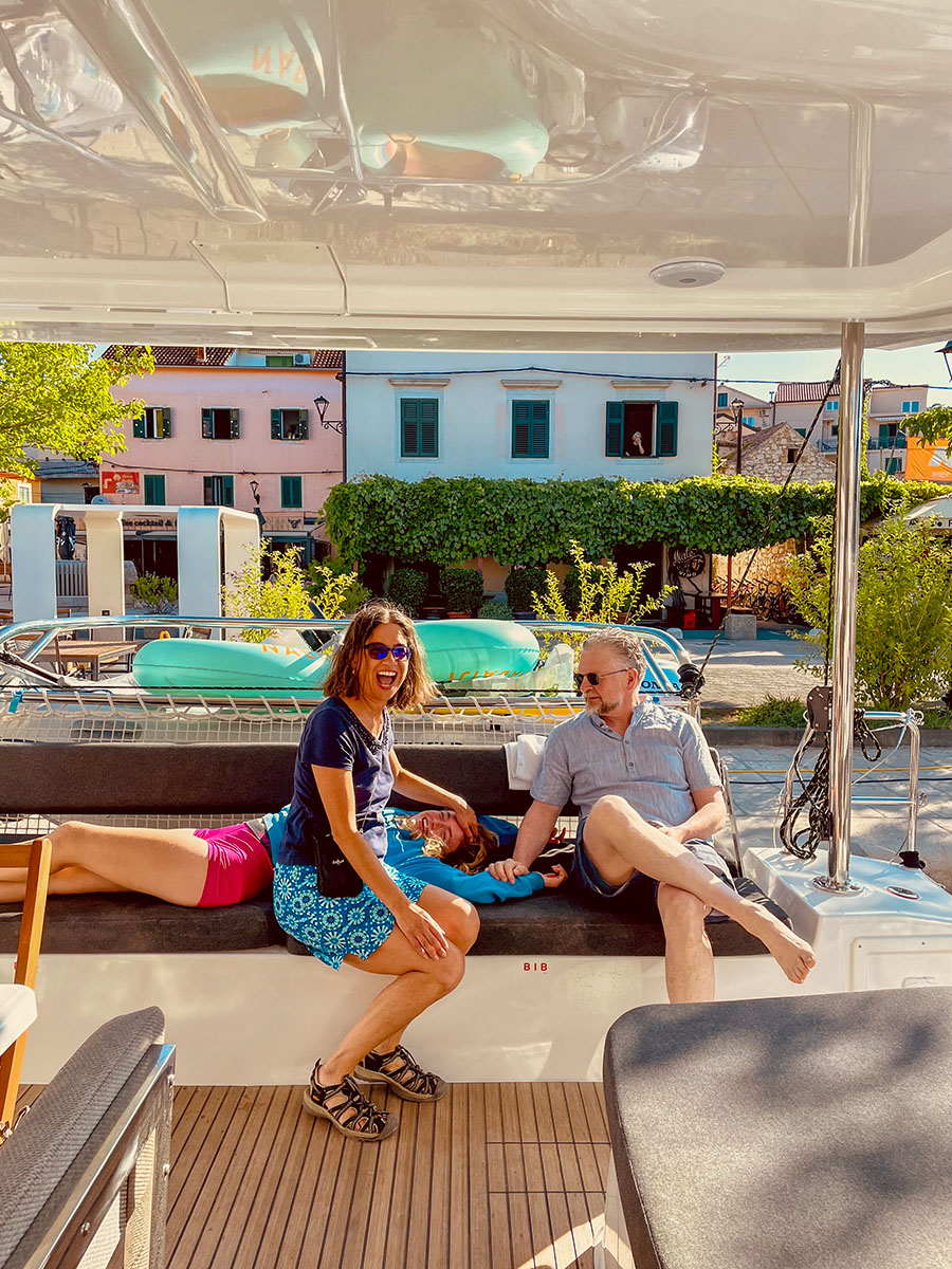 Guests relaxing in the catamaran cockpit beside the waterfront in Skradin