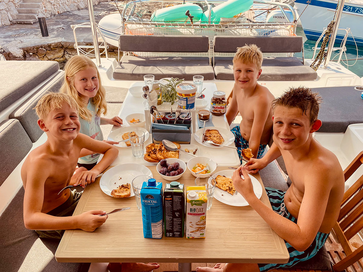 Young guests smiling around the catamaran dining table