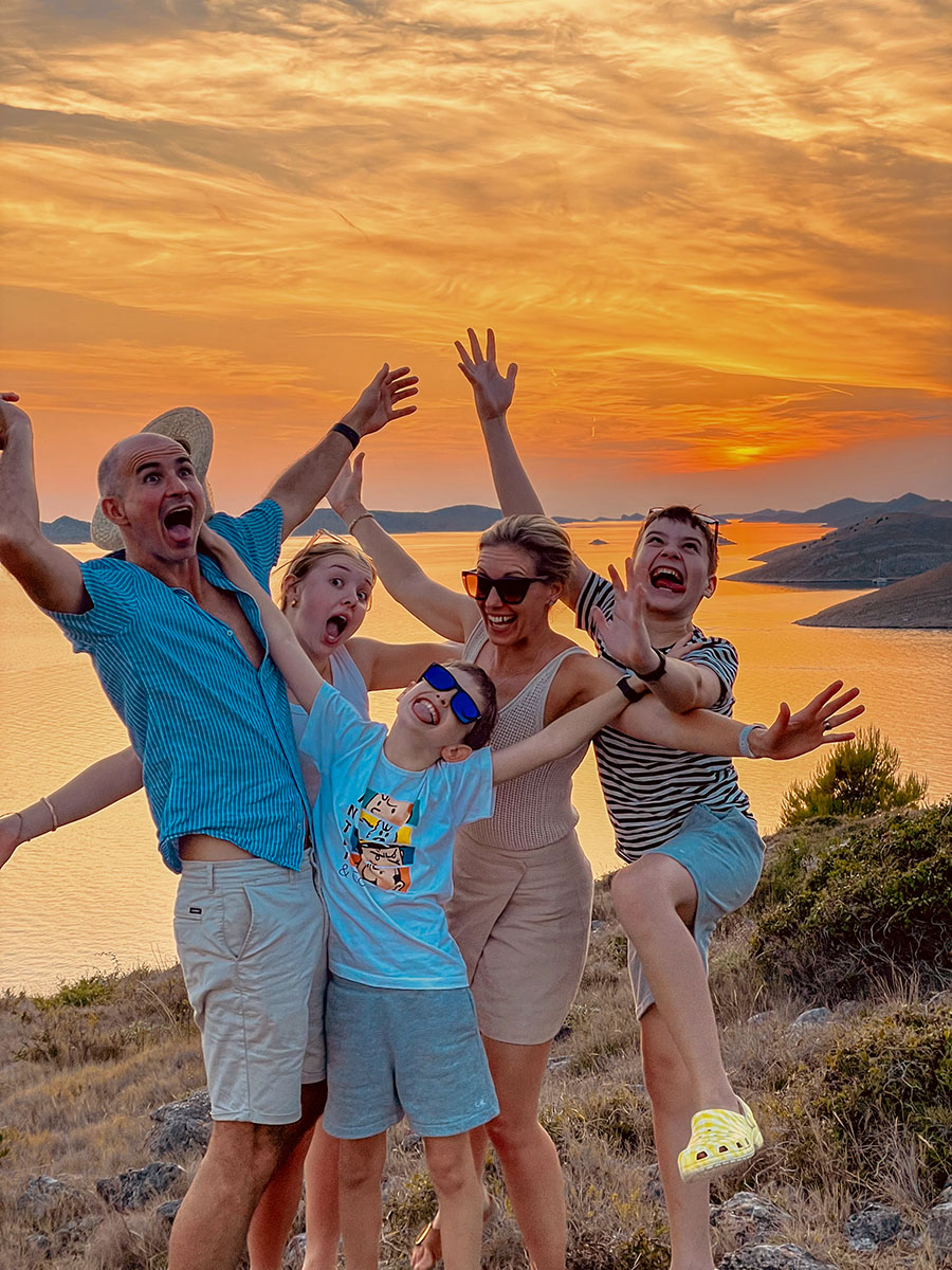 Sailing group celebrating at a sunset viewpoint