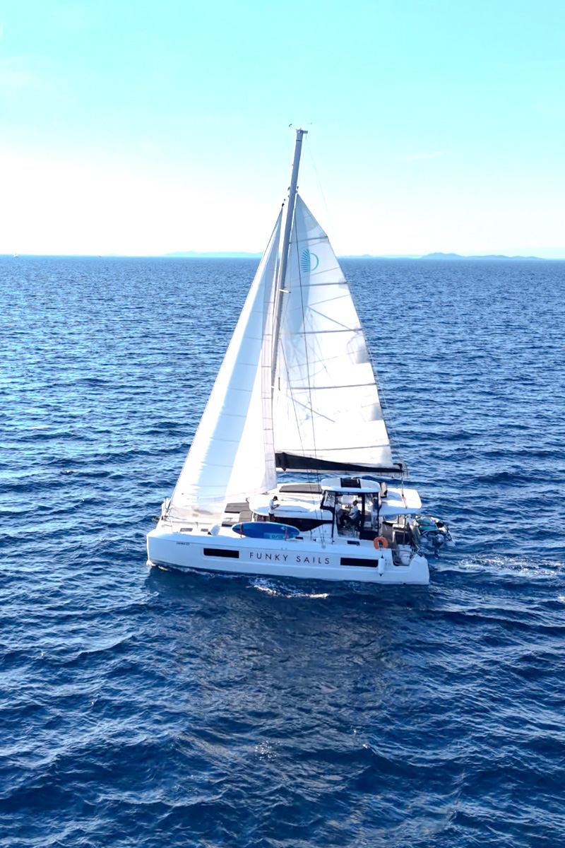 Funky Sails catamaran sailing across blue water, viewed from above