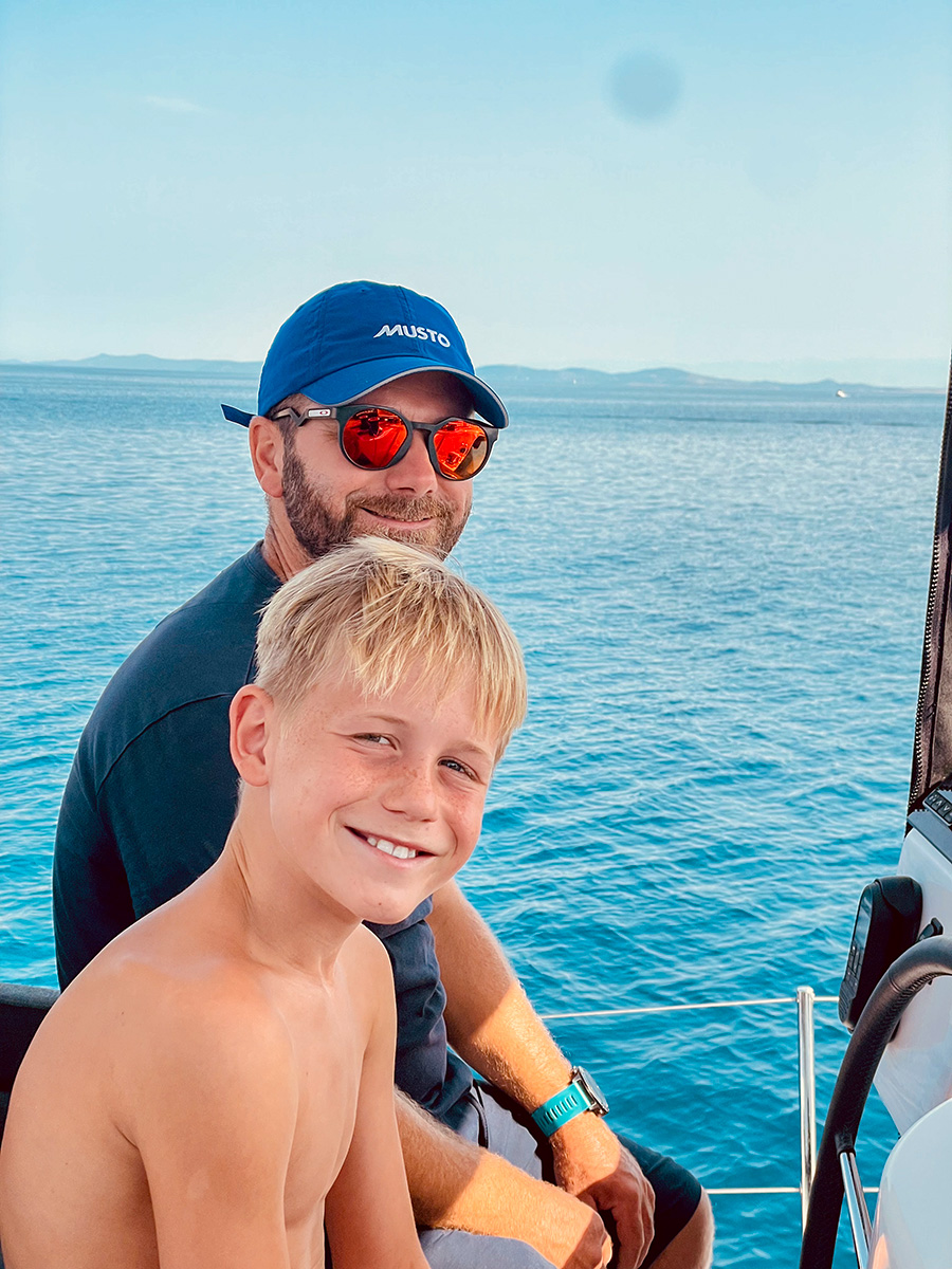 Adult crew member and child smiling together on board